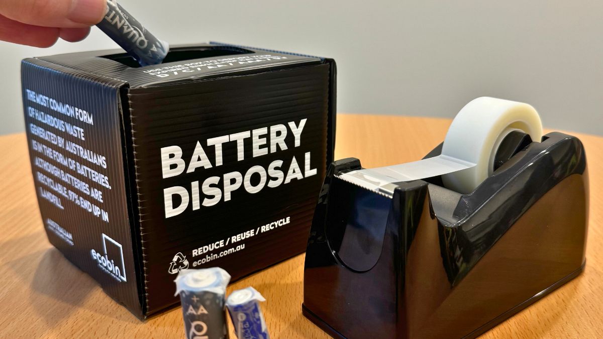 Taped batteries being placed into a safe battery disposal box at WM Waste