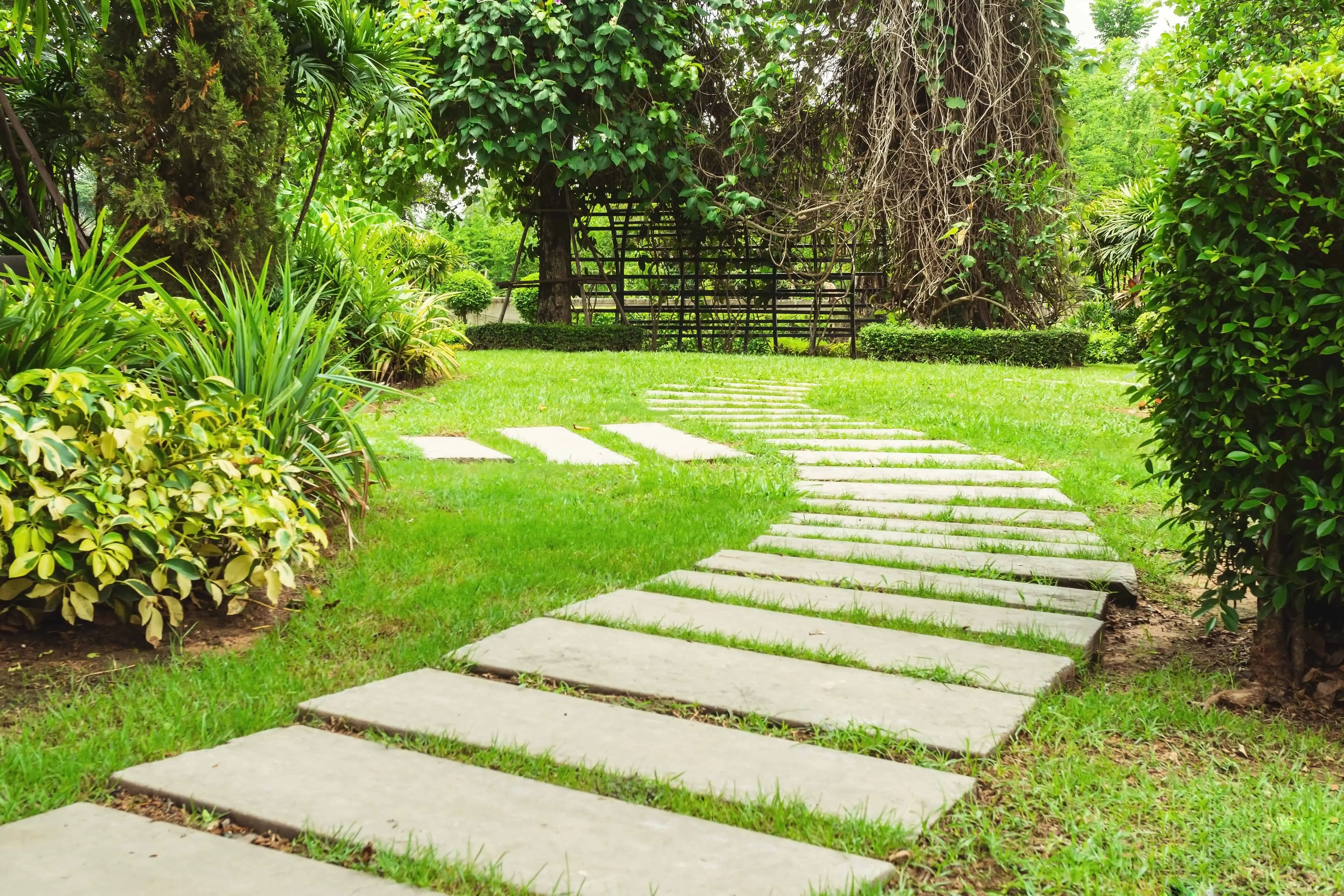 Garden landscape with intersecting pathways_ vibrant lawns_ colorful shrubs_ and brick pathways