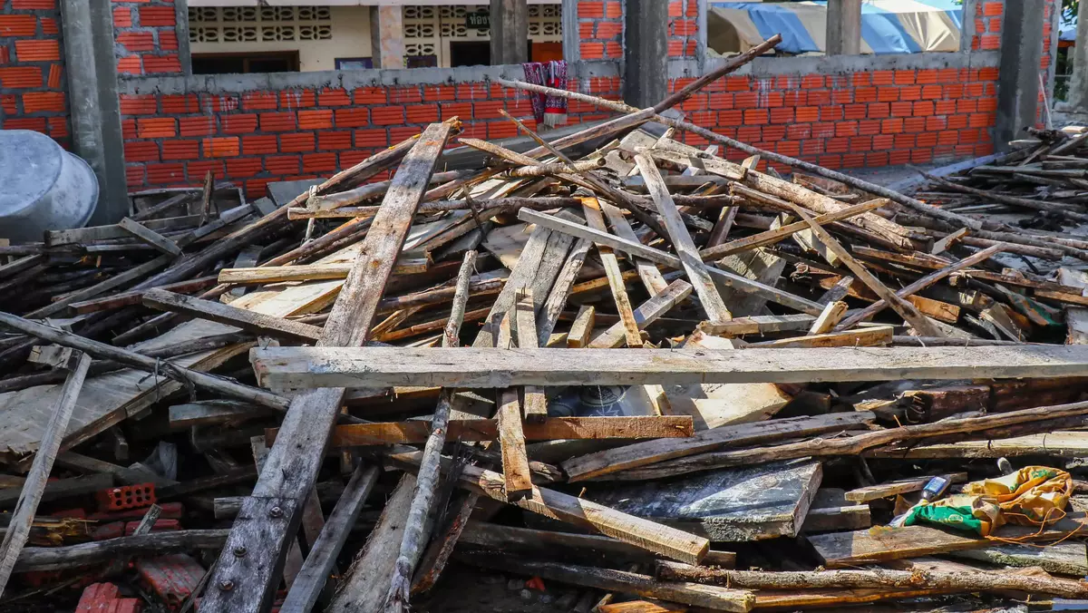 Pile of wooden planks and construction debris at a site